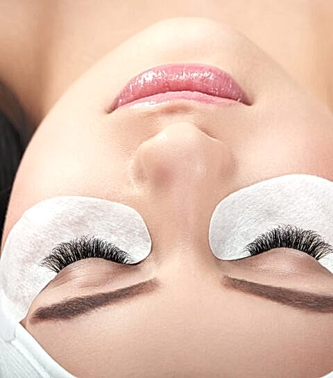 Photo comparison of woman's normal and fake enlarged lashes.